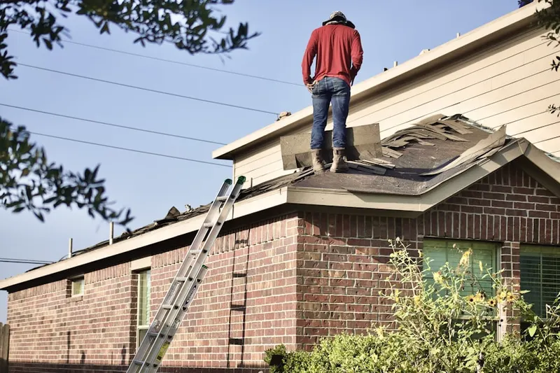 Professional roofer working on a residential roof in Village Manor
